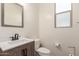 Modern half bathroom with a stylish vanity, neutral tones, and a framed mirror at 19771 W Woodlands Ave, Buckeye, AZ 85326