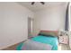 Bright bedroom features a comfy bed with blue quilt, side table and a ceiling fan at 19771 W Woodlands Ave, Buckeye, AZ 85326