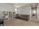 Relaxing bonus room with couch, a chair with ottoman, and shelving for books and décor at 19771 W Woodlands Ave, Buckeye, AZ 85326