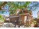 A two-story house with brown siding, well-manicured landscaping, a covered porch and a two-car garage at 19771 W Woodlands Ave, Buckeye, AZ 85326