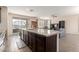 Kitchen island features a granite countertop, seating, and overlooks the living room at 19771 W Woodlands Ave, Buckeye, AZ 85326