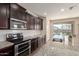 Beautiful kitchen with granite countertops, stainless steel appliances, and dark wood cabinets at 19771 W Woodlands Ave, Buckeye, AZ 85326