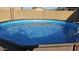 Backyard above ground pool filled with water on a sunny day at 19771 W Woodlands Ave, Buckeye, AZ 85326