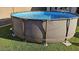 Close up view of above ground pool with ladder on green lawn at 19771 W Woodlands Ave, Buckeye, AZ 85326