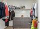 Organized walk-in closet featuring shelving, hanging rods, and a dresser for ample storage space at 19771 W Woodlands Ave, Buckeye, AZ 85326