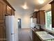 Traditional kitchen with wooden cabinets, white appliances, and granite countertops at 2206 S Ellsworth Rd # 1736, Mesa, AZ 85209