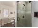 Modern bathroom featuring a tiled shower with glass door, grey vanity, toilet and stylish decorations at 22610 W Mohave St, Buckeye, AZ 85326