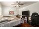Comfortable bedroom with ceiling fan, large TV, and a cozy bed with decorative pillows and black desk chair at 22610 W Mohave St, Buckeye, AZ 85326