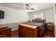 Bright bedroom with ceiling fan, a large bed with dresser, a bedside table, and a neutral color scheme at 22610 W Mohave St, Buckeye, AZ 85326