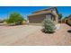 Wide driveway leading to a two-car garage, surrounded by desert landscaping at 22610 W Mohave St, Buckeye, AZ 85326