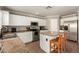 Well-lit kitchen with stainless steel appliances, including a refrigerator, microwave, and a kitchen island with seating at 22610 W Mohave St, Buckeye, AZ 85326