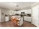 Charming kitchen with white cabinetry, stainless steel appliances, and a functional center island with stools at 22610 W Mohave St, Buckeye, AZ 85326