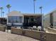 Charming mobile home with a cozy covered patio and well-maintained landscaping with palm trees at 2290 S Seminole Dr, Apache Junction, AZ 85119