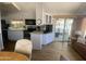 Kitchen and living area with white cabinets, wood floors, and access to a screened-in porch at 2290 S Seminole Dr, Apache Junction, AZ 85119