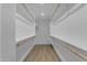 This is a clean, well-organized walk-in closet with wood floors, white walls, shelving, and hanging rods at 2402 N 15Th St, Phoenix, AZ 85006