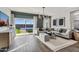 Open living room with backyard view, gray tile flooring, large sectional sofa, and decorative lighting at 24065 W Pima St, Buckeye, AZ 85326