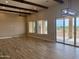 Open-concept living room with wooden beams, tile flooring, and large windows with scenic views at 25927 N 149Th Dr, Surprise, AZ 85387