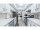 Galley kitchen with white cabinets, quartz countertops, black appliances and subway tile backsplash at 2615 N Hayden Rd # 114, Scottsdale, AZ 85257