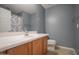Cozy bathroom featuring vanity and sink combo, a mirror, toilet and a shower with floral shower curtain at 30268 W Sheila Ln, Buckeye, AZ 85396