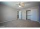 Bright bedroom featuring a ceiling fan, closet with sliding doors, and an adjoining hallway at 30268 W Sheila Ln, Buckeye, AZ 85396