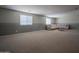 Large living room with carpeted floor, decorative trim, and plentiful light from two windows at 30268 W Sheila Ln, Buckeye, AZ 85396