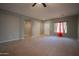 Open-concept living room with tile flooring, neutral carpet, and an airy atmosphere at 30268 W Sheila Ln, Buckeye, AZ 85396
