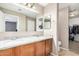 Bathroom with dual sinks, granite countertops, and a large mirror at 3228 W Saint Anne Ave, Phoenix, AZ 85041