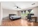 Large bedroom with wood floors, fan, natural light, desk, and chair at 3228 W Saint Anne Ave, Phoenix, AZ 85041