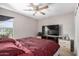 Neutral bedroom features a ceiling fan, large television and bedside tables with drawers at 3228 W Saint Anne Ave, Phoenix, AZ 85041