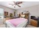 Neutral bedroom features a ceiling fan and headboard with artwork, pictures and flowers at 3228 W Saint Anne Ave, Phoenix, AZ 85041