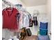 Walk-in closet with metal racking system, shelves, rods, storage bins and luggage at 3228 W Saint Anne Ave, Phoenix, AZ 85041