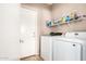 Laundry room with washer, dryer and shelves with cleaning supplies at 3228 W Saint Anne Ave, Phoenix, AZ 85041