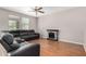 Comfortable living room features laminate flooring, a ceiling fan, and a cozy electric fireplace at 3228 W Saint Anne Ave, Phoenix, AZ 85041