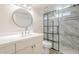 Bright bathroom features a modern vanity with round mirror and a glass enclosed shower with gray marble tile at 3701 W Villa Maria Dr, Glendale, AZ 85308