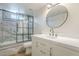 Modern bathroom features a updated vanity with round mirror and a glass enclosed shower with gray marble tile at 3701 W Villa Maria Dr, Glendale, AZ 85308