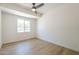 Neutral room with wood-look floors, bright window, and modern ceiling fan at 3701 W Villa Maria Dr, Glendale, AZ 85308
