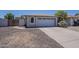 An exterior view shows the driveway and garage of a neutral toned one-story home at 3701 W Villa Maria Dr, Glendale, AZ 85308