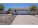 A cozy single-story home showing the garage, arched window and low maintenance landscaping at 3701 W Villa Maria Dr, Glendale, AZ 85308