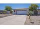 A one-story home exterior features a two car garage, simple xeriscape and a concrete driveway at 3701 W Villa Maria Dr, Glendale, AZ 85308