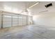 Spacious garage with a white door, overhead lighting, and ample room for parking and storage at 3701 W Villa Maria Dr, Glendale, AZ 85308