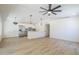 Open concept floor plan with wood-look floors, stainless appliances, pendant lights and fan at 3701 W Villa Maria Dr, Glendale, AZ 85308