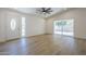 A bright living room with wood-look floors, a modern fan, and slider door to the backyard at 3701 W Villa Maria Dr, Glendale, AZ 85308