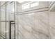 Close up of the shower showcasing the elegant gray and white marble tile, a window, and modern shower fixtures at 3701 W Villa Maria Dr, Glendale, AZ 85308