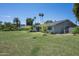 Spacious backyard with lush green lawn, mature trees, and a view of the home's exterior at 4125 N 64Th St, Scottsdale, AZ 85251