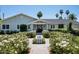 Charming single-story home featuring a symmetrical facade, gray siding, and a beautifully landscaped front yard with a small fountain at 4125 N 64Th St, Scottsdale, AZ 85251