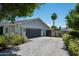 Detached garage with paved driveway, gray exterior and surrounded by well-maintained landscaping at 4125 N 64Th St, Scottsdale, AZ 85251