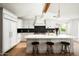 Bright modern kitchen features white cabinets, stainless steel appliances, an island with counter seating, and hardwood floors at 4125 N 64Th St, Scottsdale, AZ 85251