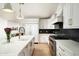 Modern kitchen featuring white cabinets, stainless steel appliances, an island with a sink, and a black backsplash at 4125 N 64Th St, Scottsdale, AZ 85251