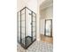 Modern bathroom showcasing a frameless glass shower with black grid design and contrasting black fixtures and patterned tile floors at 4235 S Snowcap Dr, Gilbert, AZ 85297