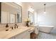 Bright bathroom featuring double sinks, white cabinets, and subway tile wainscoting, with a freestanding tub in the corner at 4235 S Snowcap Dr, Gilbert, AZ 85297